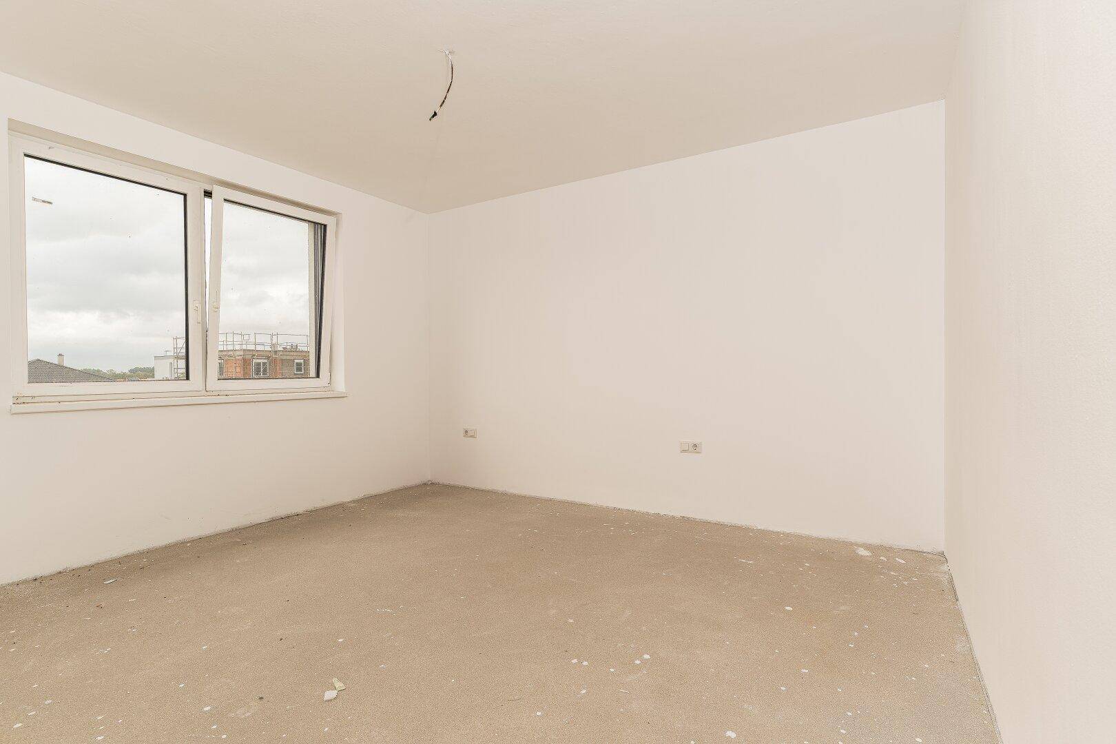 Unfertiges Schlafzimmer mit großen Fenstern und viel natürlichem Licht.