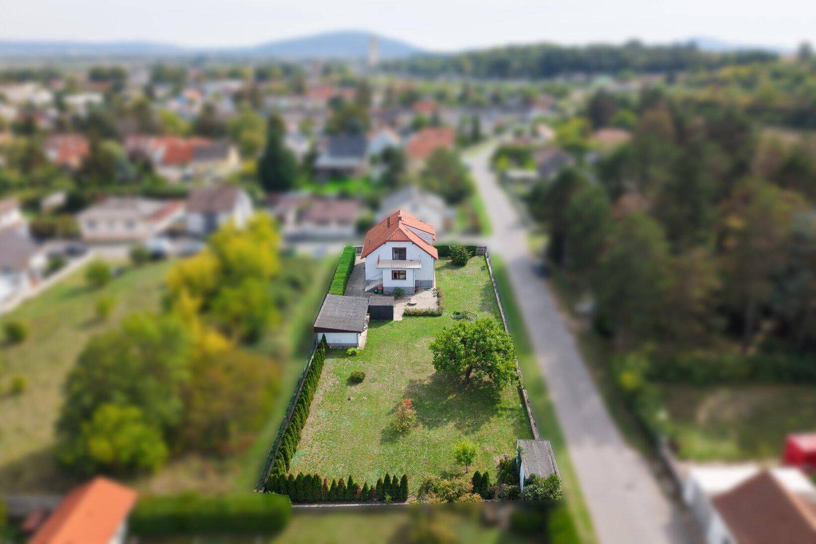 Weitläufige Luftaufnahme des Grundstücks mit Einfamilienhaus und umliegender Wohngegend.