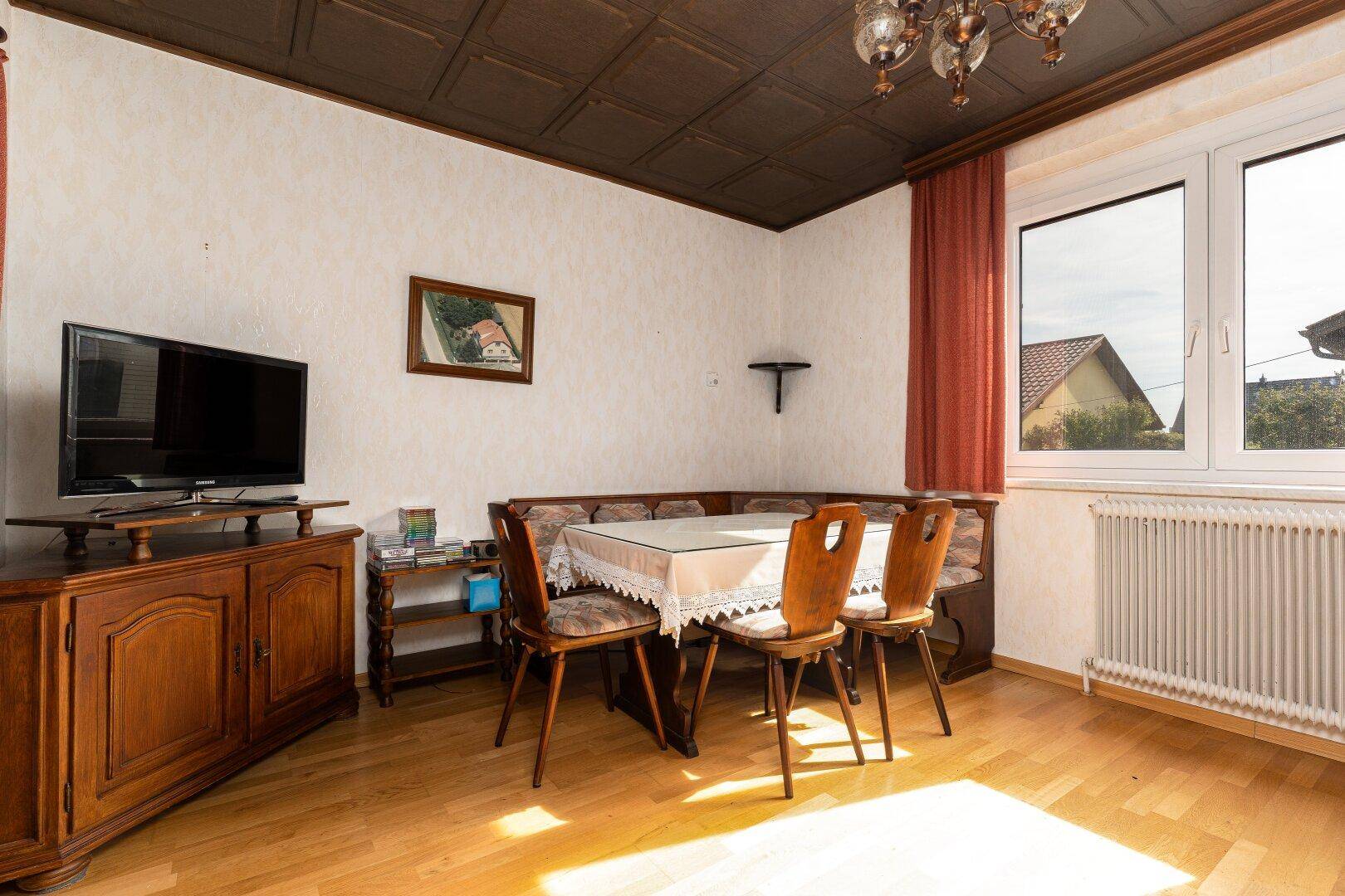 Esszimmer mit Holztisch, Eckbank und traditionellen Holzmöbeln, hell und einladend.