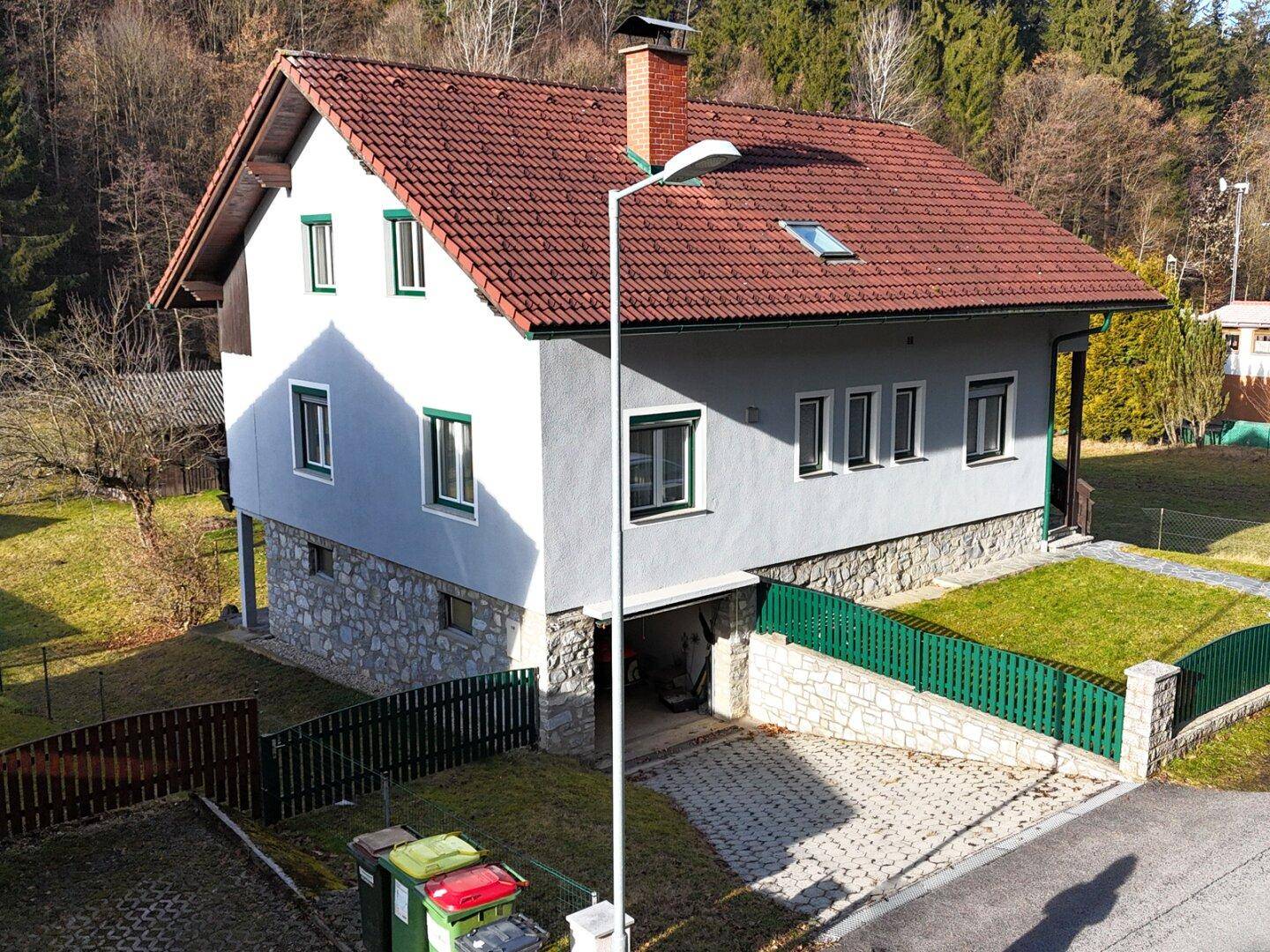 Rückansicht des Hauses mit Garagenzufahrt und gepflegtem Vorgartenbereich.
