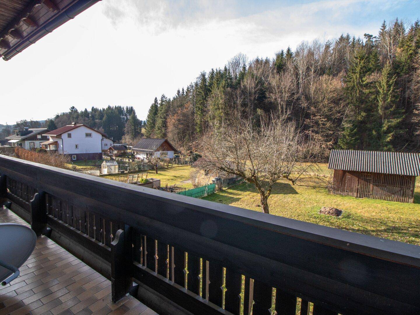 Balkon mit Panoramablick über die ländliche Umgebung und angrenzende Häuser.