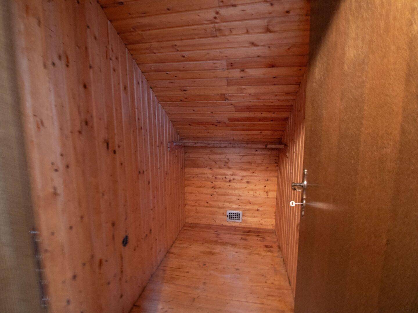 Abstellraum mit Holzverkleidung an Wänden und Decke, funktional und einfach.