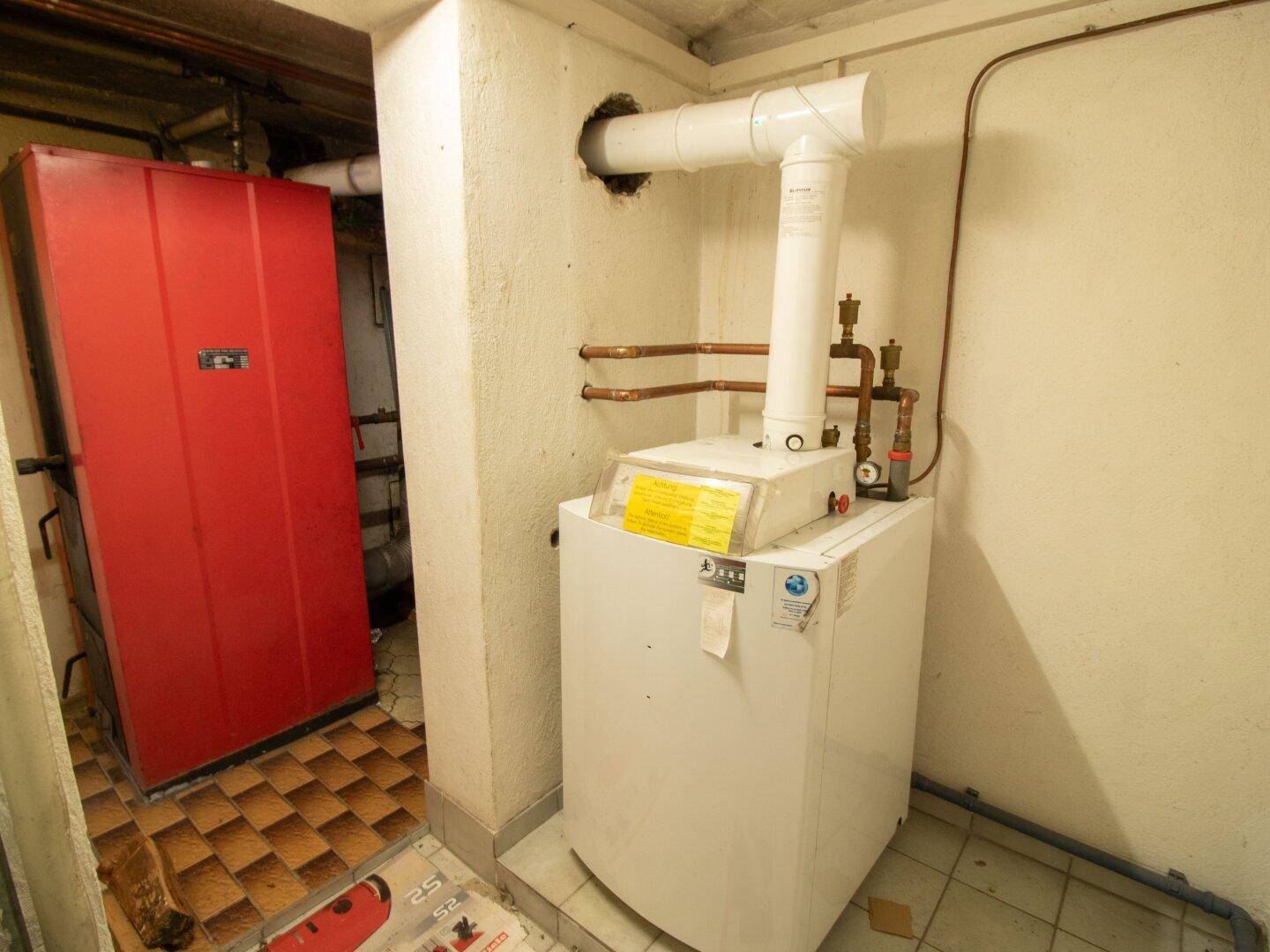 Heizraum im Keller mit Heizungsanlage und Warmwasserspeicher.