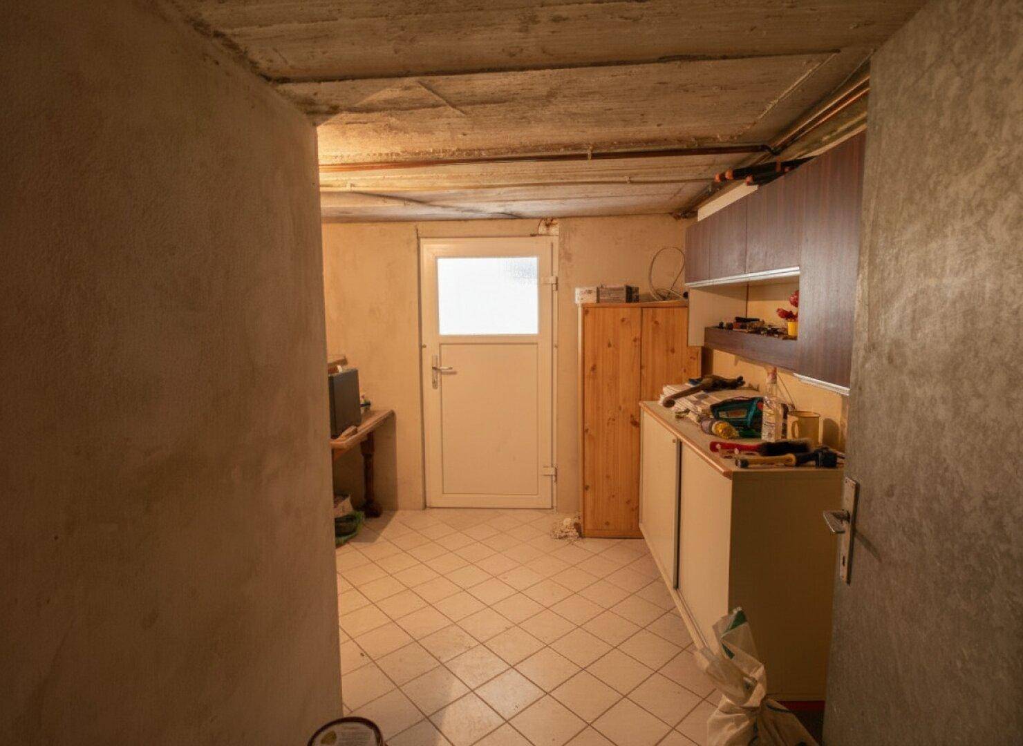 Kellerraum mit Fenster und Regalen, ideal als Werkstatt oder Lager.