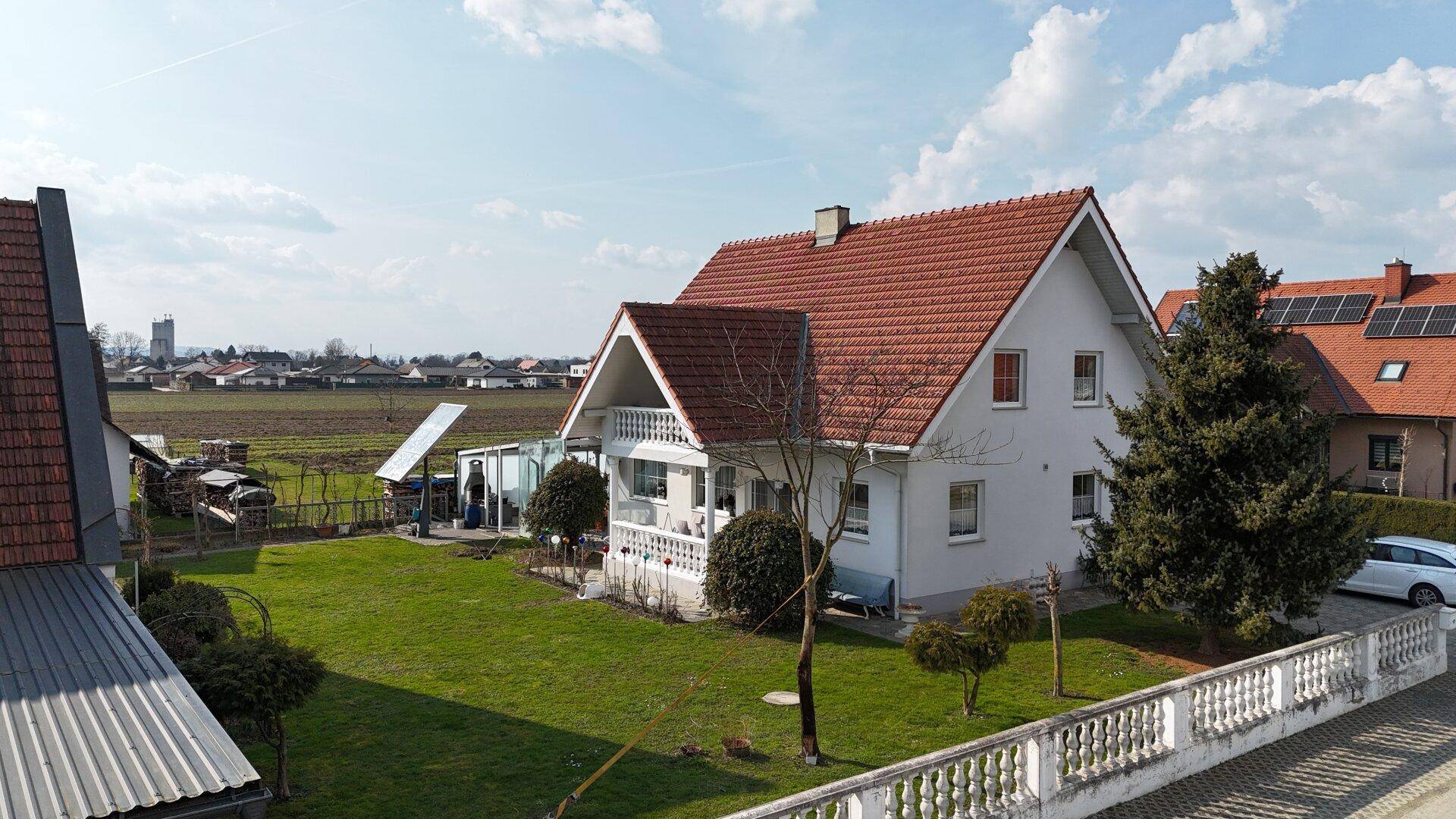 Einfamilienhaus mit Garten, Terrasse und Blick auf die weiten Felder.