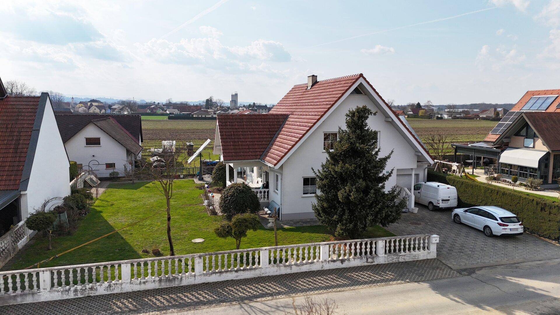 Freistehendes Haus mit großem Garten, Einfahrt und ländlicher Umgebung.