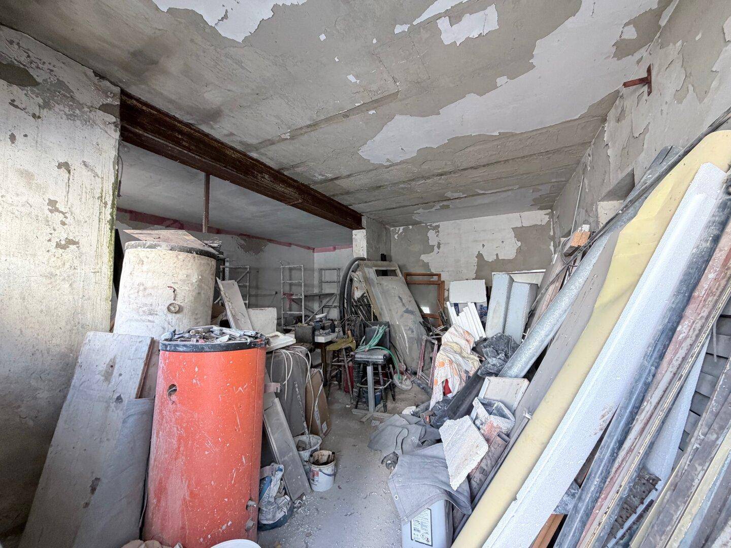 Unaufgeräumter Lagerraum oder Keller mit Baumaterialien und alten Gegenständen.