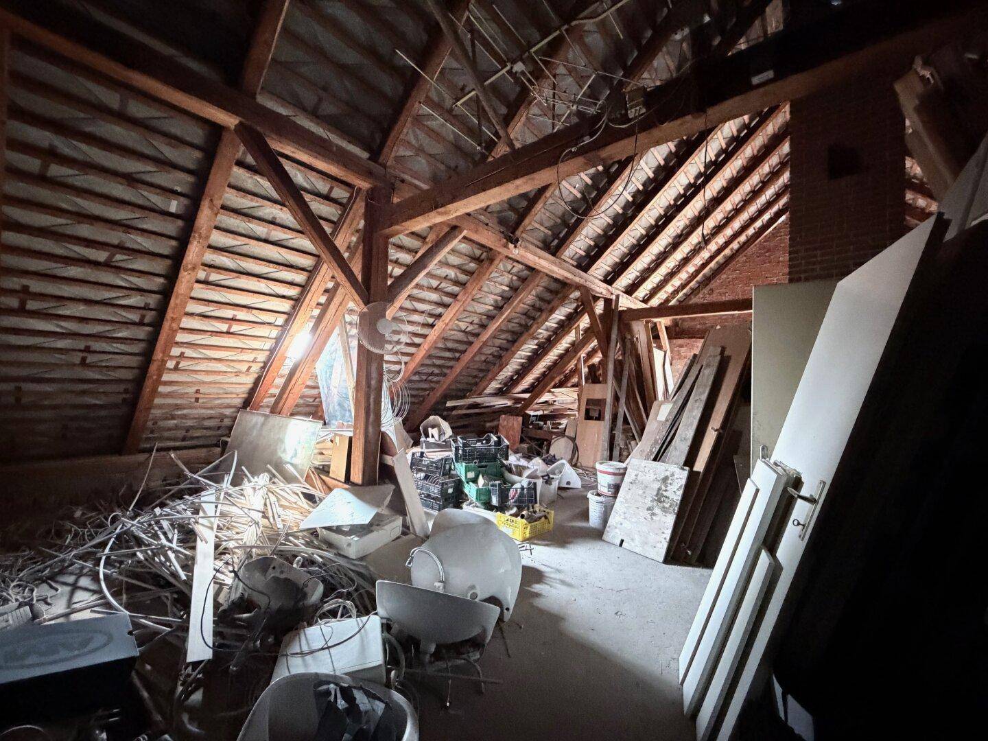 Großer, unausgebauter Dachboden mit sichtbarer Holzkonstruktion und viel Stauraum.