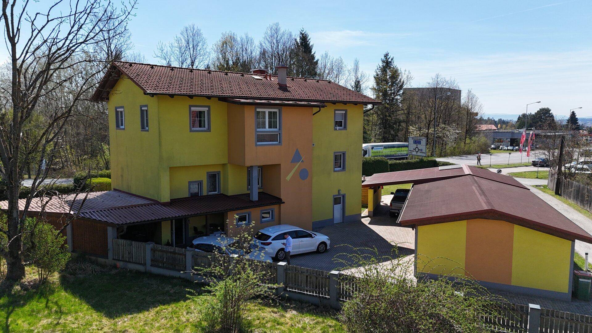 Vogelperspektive des Wohnhauses mit mehreren Stellplätzen und Nebengebäuden.