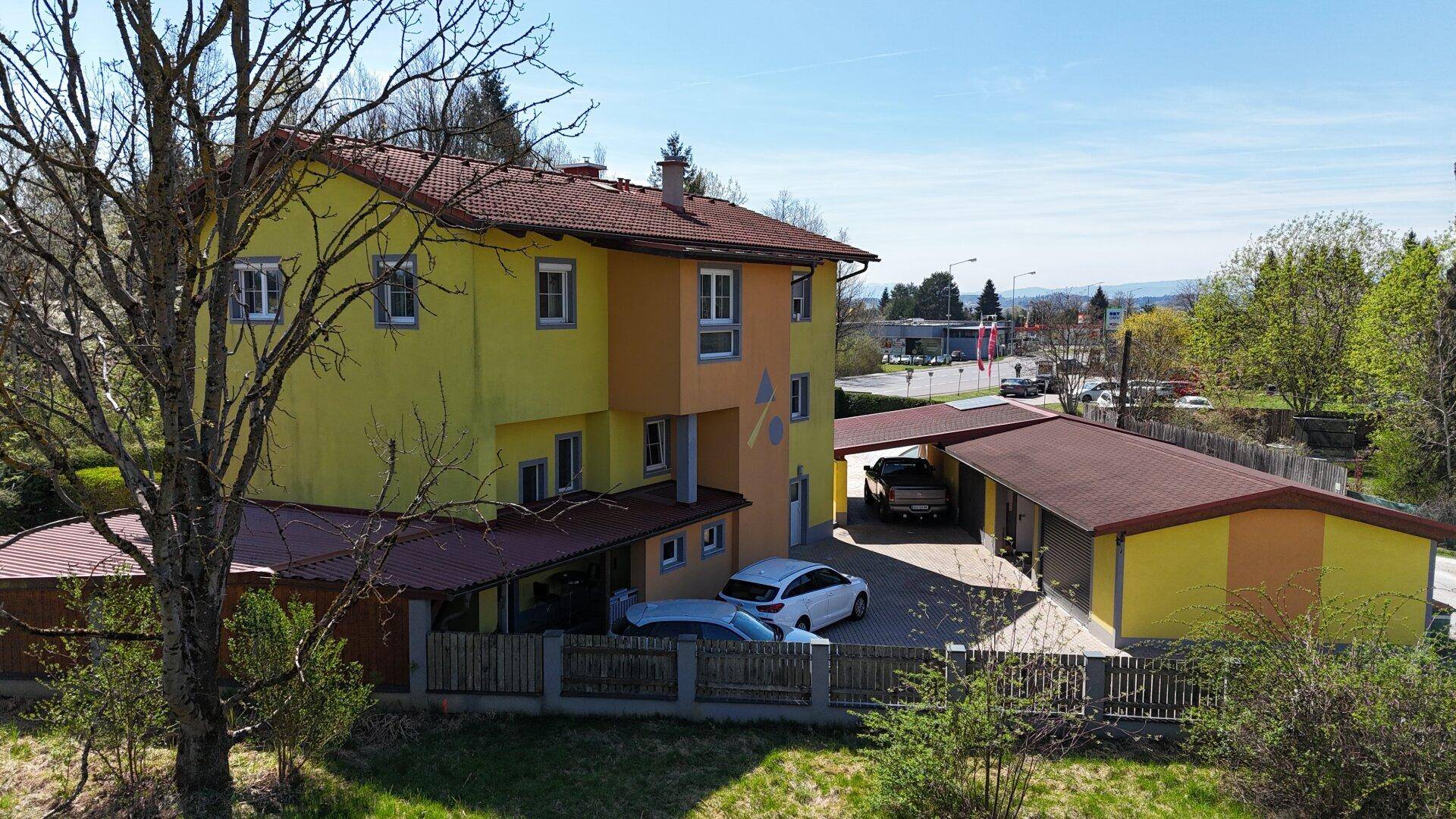 Luftaufnahme des Wohnhauses mit Carport und Nebengebäuden in ländlicher Umgebung.