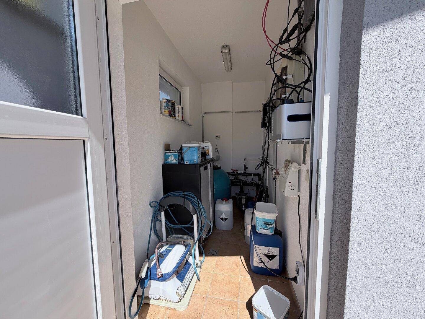 Technikraum für den Pool mit Pumpen, Filtern und Reinigungszubehör.