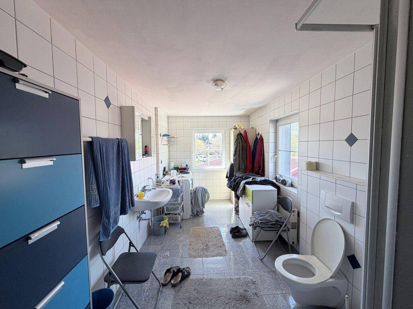 Geräumiges Badezimmer mit Toilette, Waschtisch und Fenster, auch als Waschraum nutzbar.