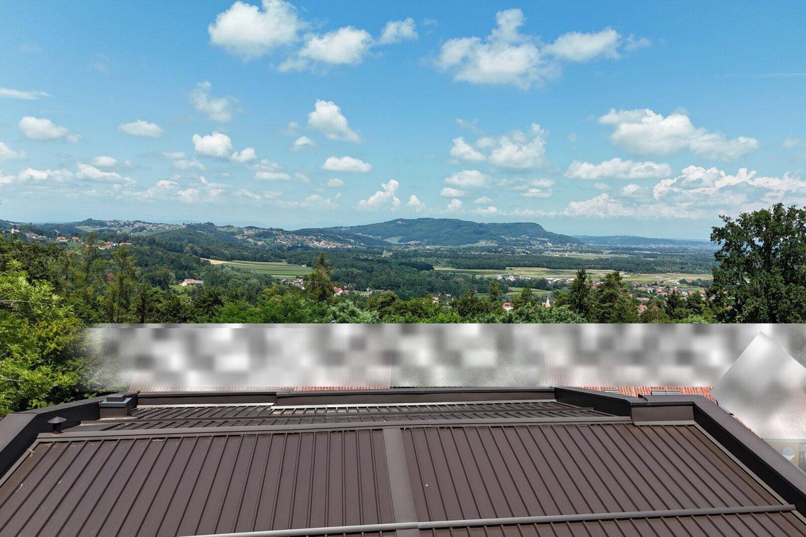 Weitläufiger Landschaftsblick von einem modernen Dach mit blauem Himmel und Wolken.