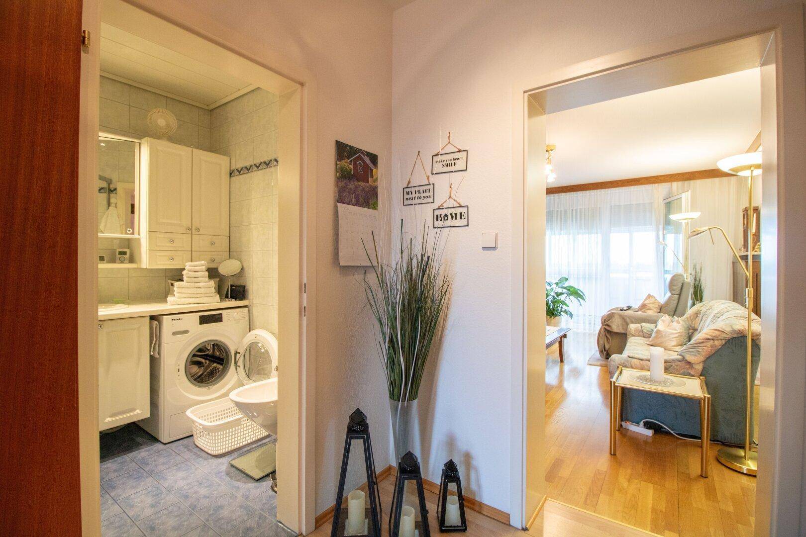 Eingangsbereich mit Blick auf das Badezimmer und den hellen Wohnbereich.
