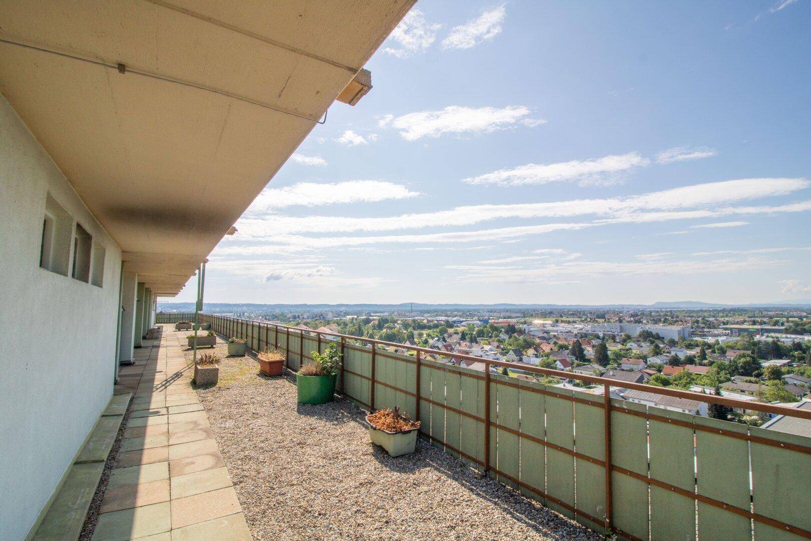 Langer Dachbereich mit Kiesbelag und weitem Panoramablick über die Stadt und die Landschaft.