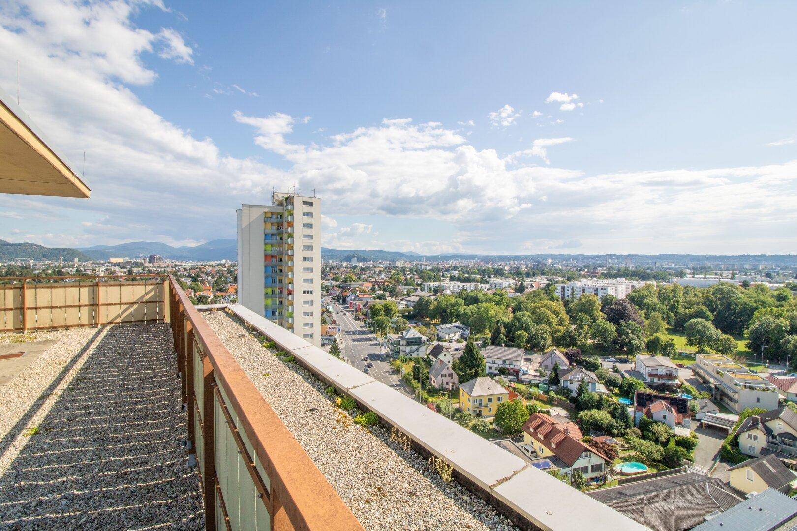 Dachbereich mit Kiesbelag und weitem Blick über die Stadt, Wohngebiete und die Landschaft.