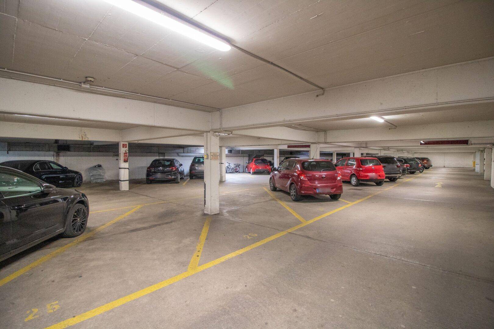 Geräumige Tiefgarage mit vielen Stellplätzen und Betonboden in einem Mehrfamilienhaus.