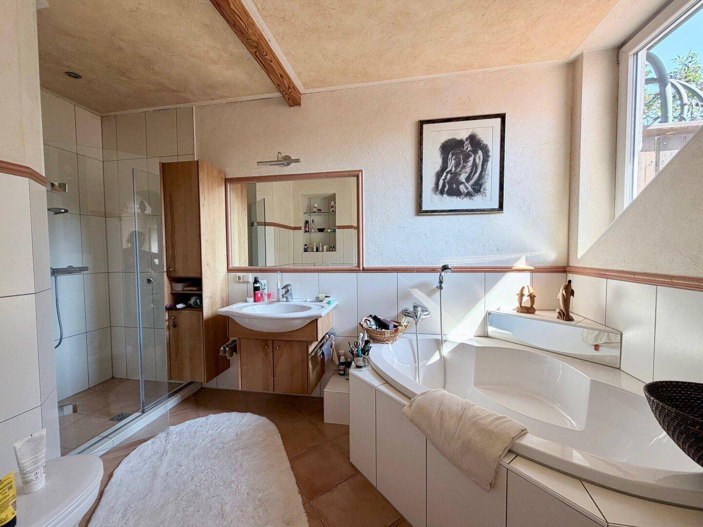 Geräumiges Badezimmer mit Eckbadewanne, Dusche und großem Fenster für viel Tageslicht.