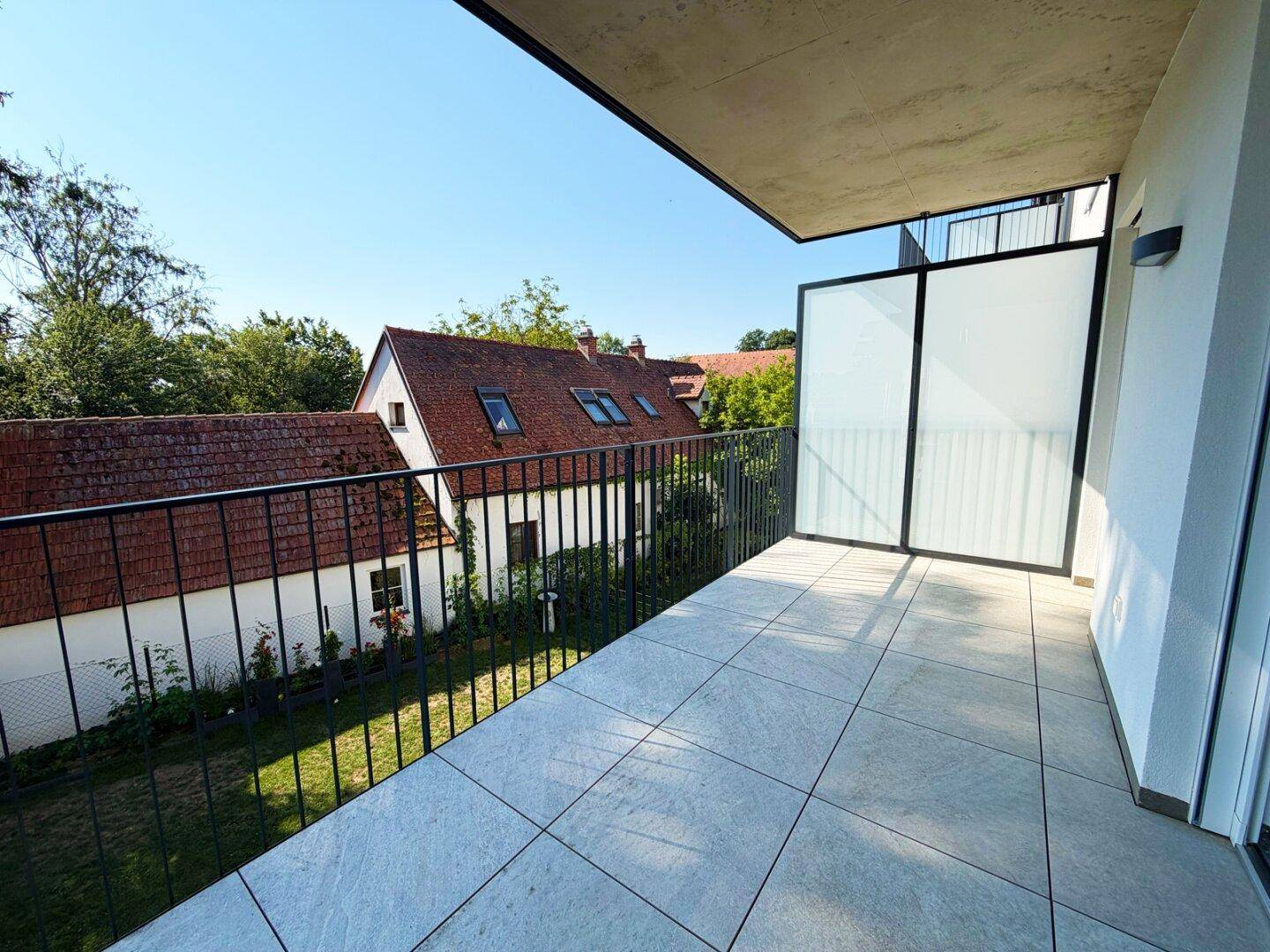 Balkon mit Blick auf charmante Nachbargebäude und grüne Umgebung, bietet eine ruhige Atmosphäre.