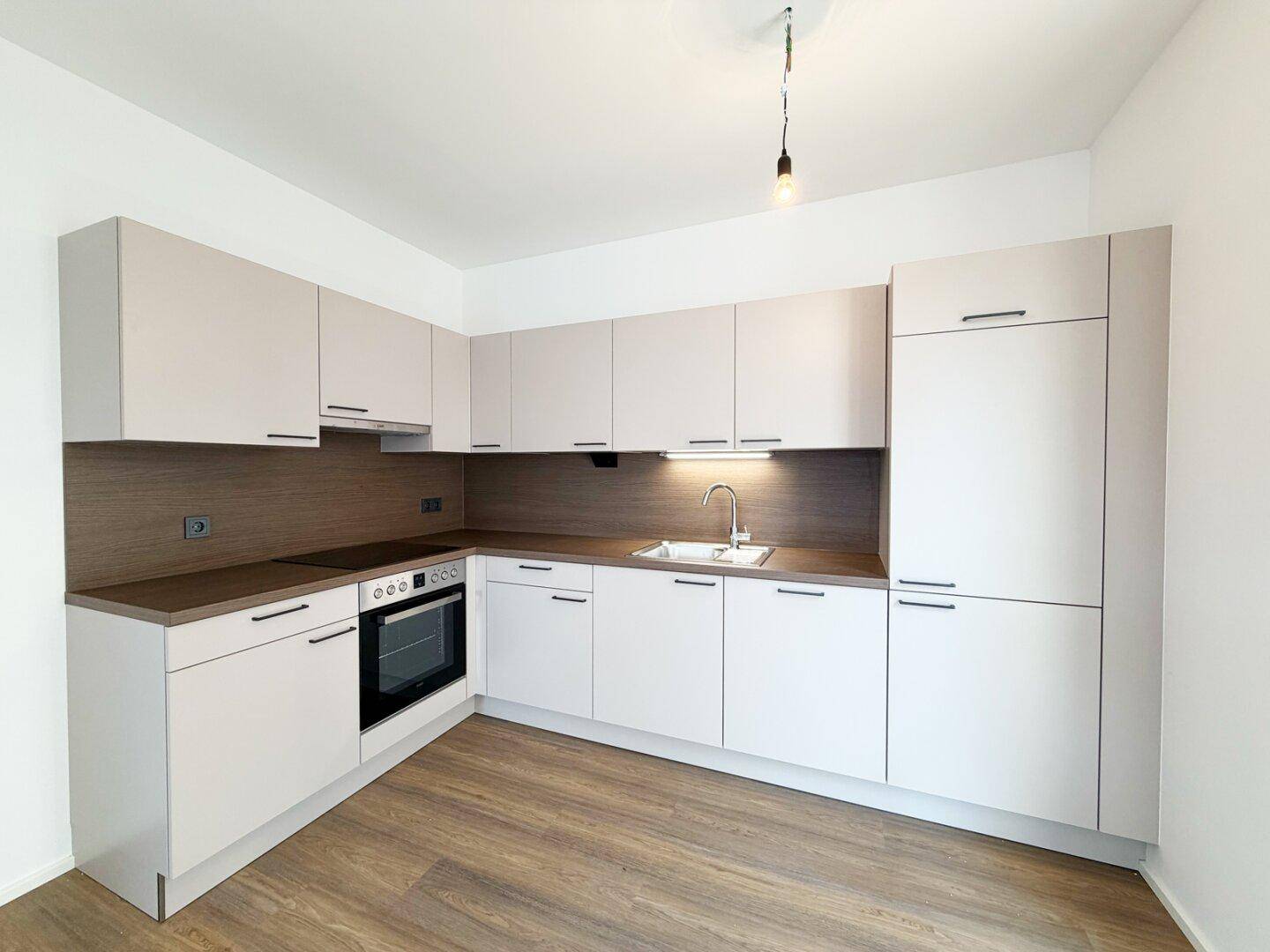 Neuwertige Einbauküche in hellem Design mit integriertem Backofen und ausreichend Stauraum.