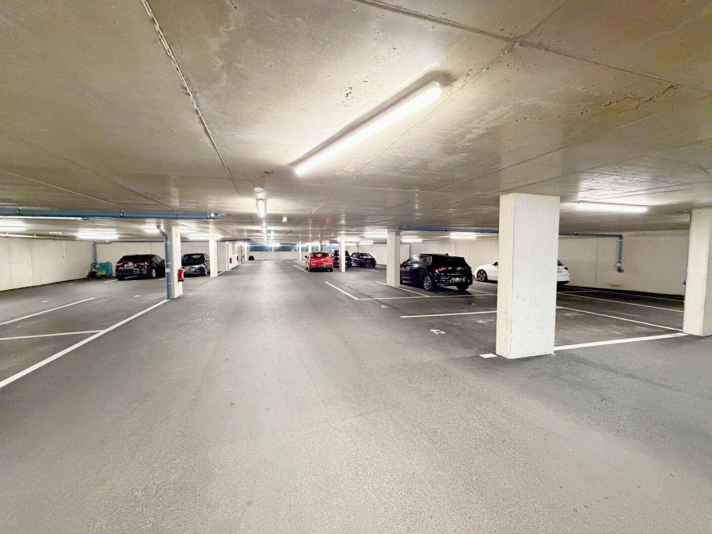 Geräumige Tiefgarage mit vielen Stellplätzen und guter Beleuchtung, bietet sicheres Parken.