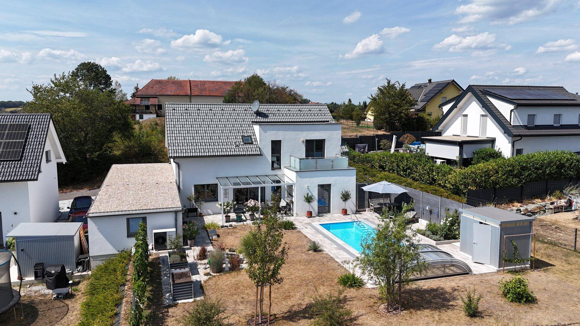 Weitläufige Ansicht eines modernen Hauses mit Pool, Garten und angrenzender ländlicher Umgebung.