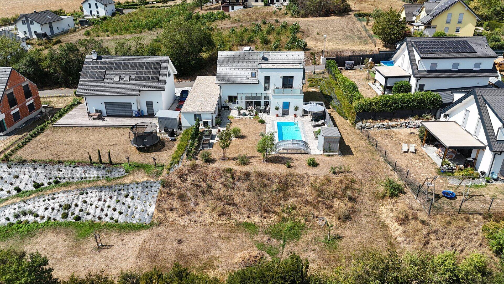 Vogelperspektive des Anwesens mit modernem Haus, Pool und weitem Blick über die ländliche Umgebung.