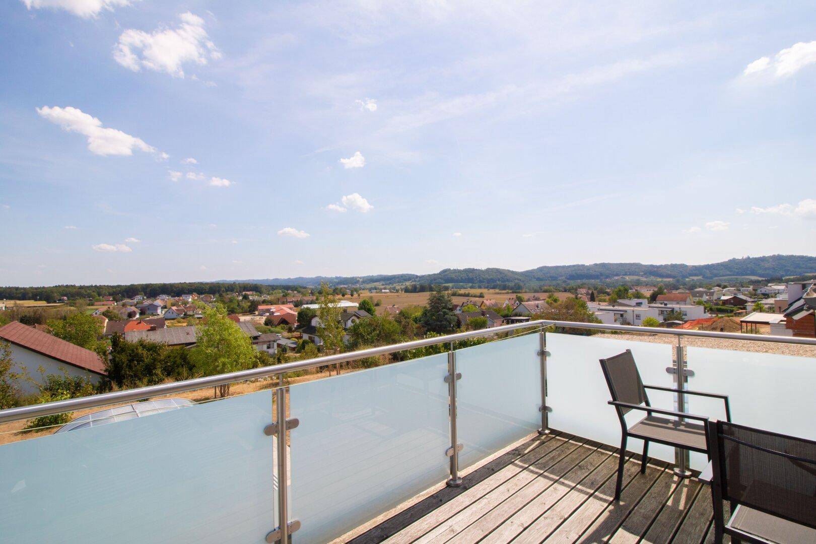 Geräumiger Balkon mit Sitzgelegenheiten und weitem Panoramablick über die ländliche Umgebung.