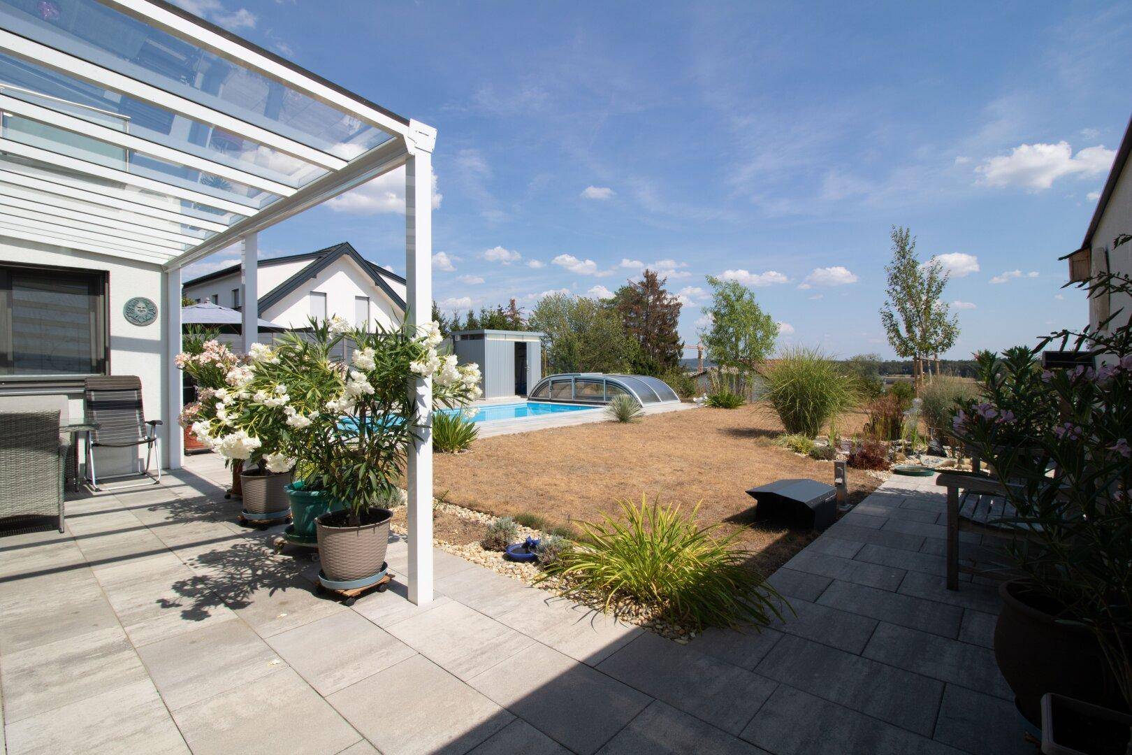 Großer Garten mit Terrasse, Pool und weitem Blick in die Landschaft.