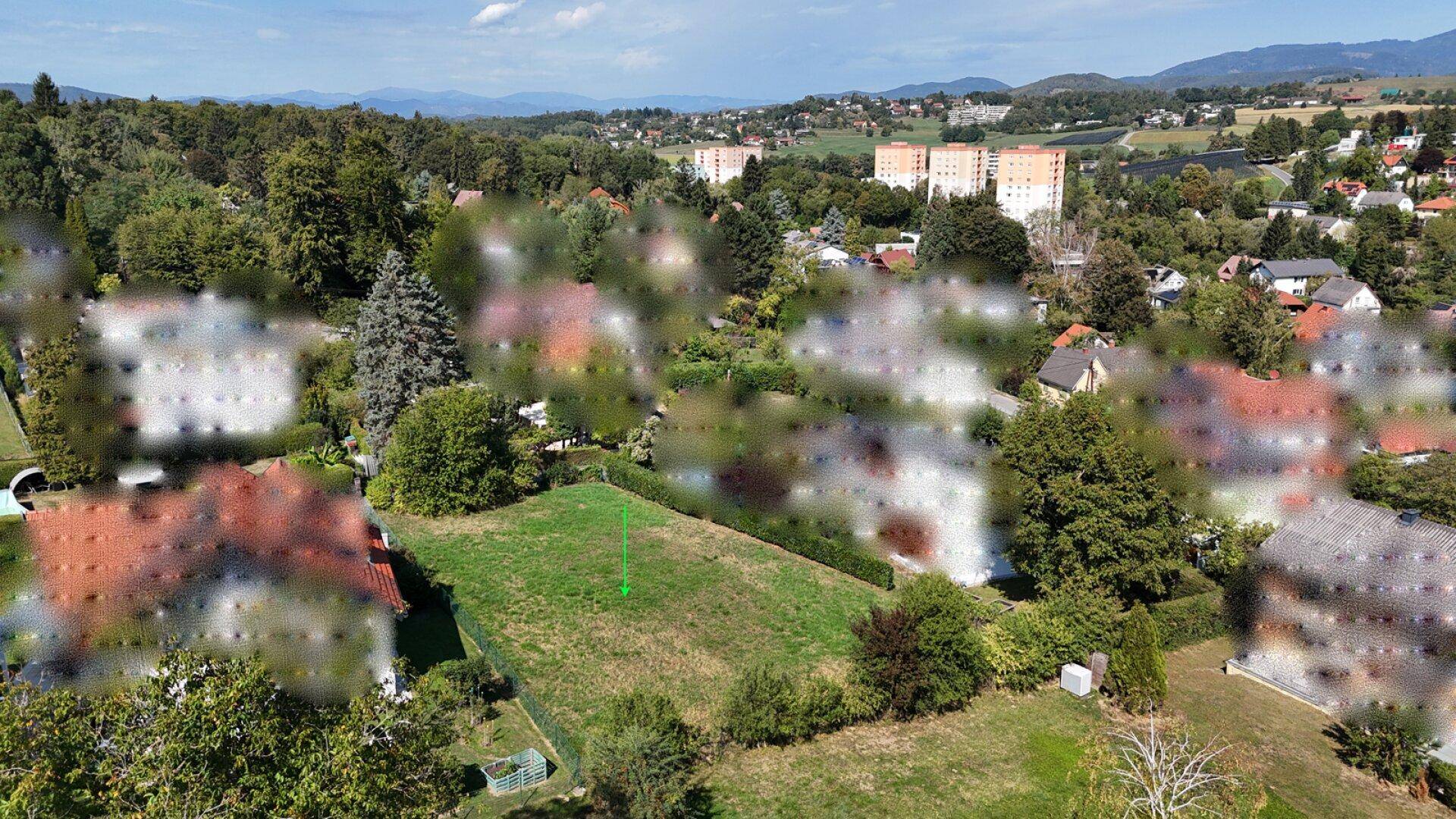 Weitläufige Luftaufnahme eines grünen Grundstücks mit Blick auf die umliegende Landschaft und Bebauung.