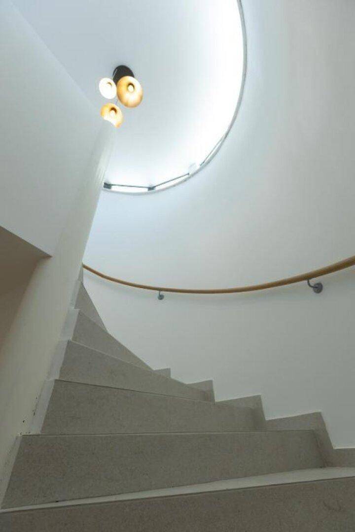 Elegante Wendeltreppe mit hellem Licht und minimalistischem Design.