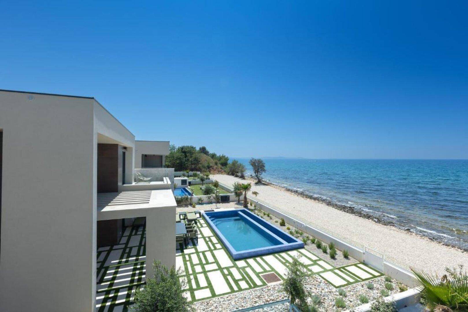 Moderne Villa mit Pool und Garten, direkt am Meer gelegen, bietet einen atemberaubenden Meerblick.