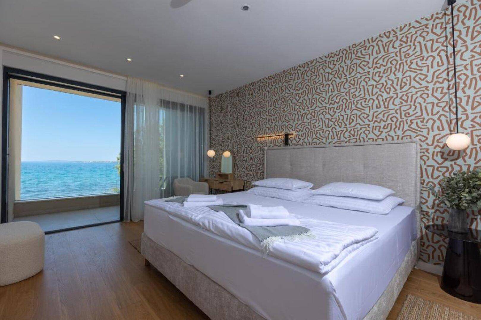Helles Schlafzimmer mit Doppelbett und direktem Zugang zum Balkon, bietet einen wunderschönen Meerblick.