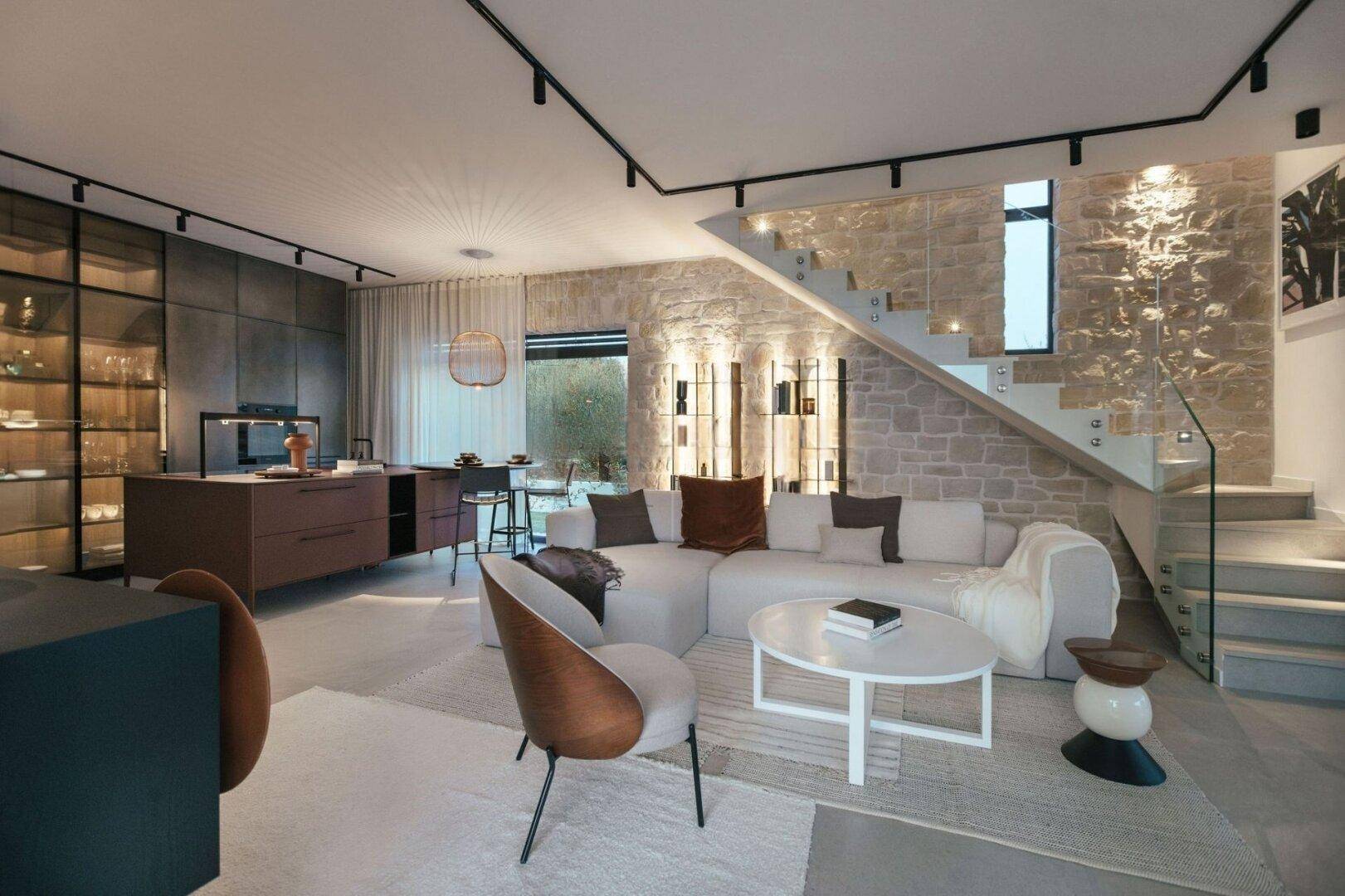 Moderner offener Wohnbereich mit Steinfassade, integrierter Küche und elegantem Design.