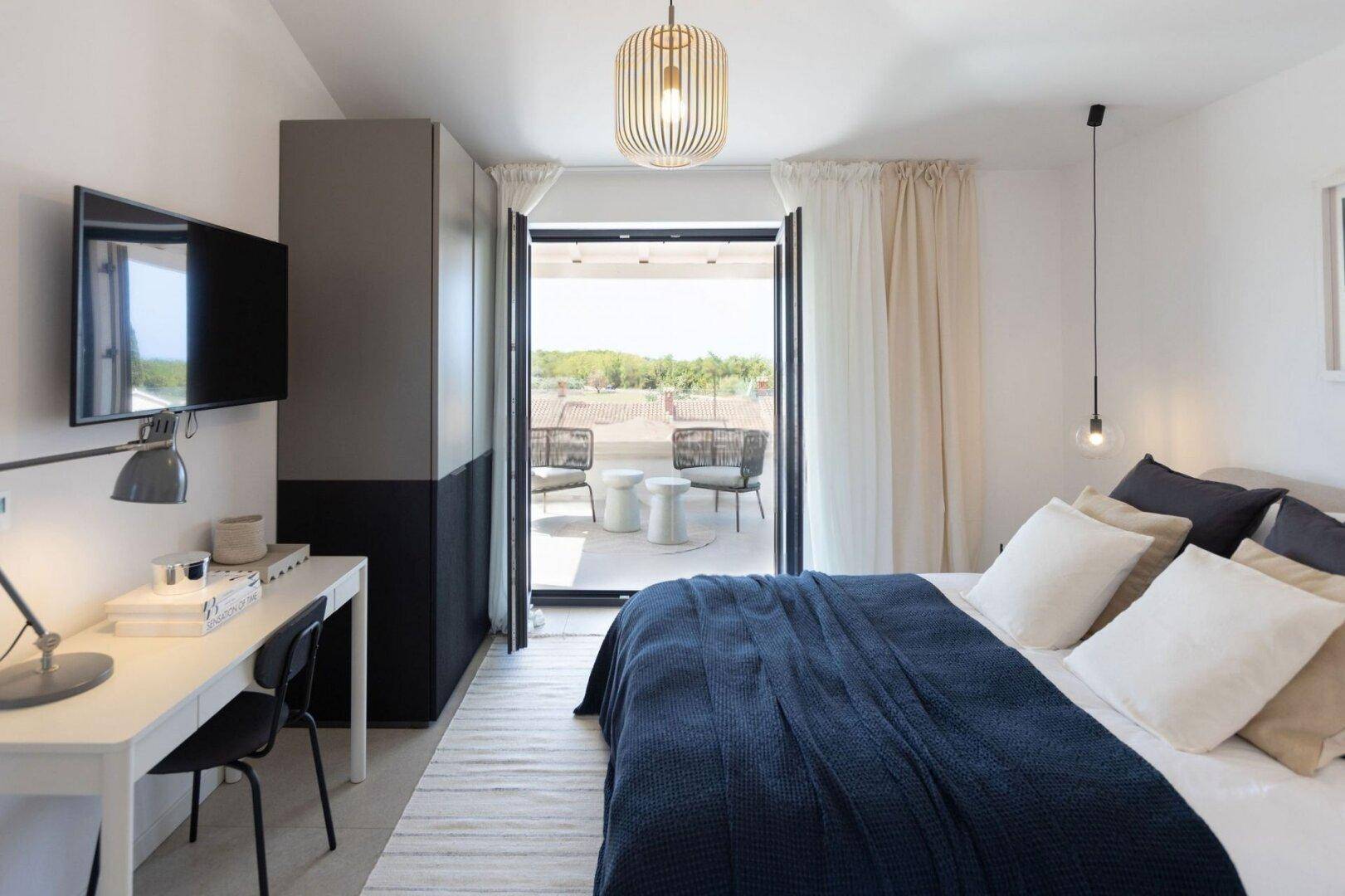 Modernes Schlafzimmer mit Zugang zu einer privaten Terrasse und integriertem Arbeitsbereich.