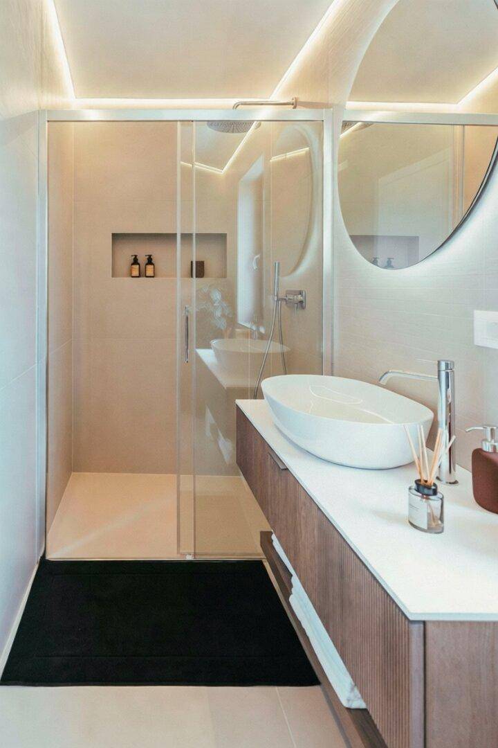 Modernes Badezimmer mit begehbarer Dusche, elegantem Waschtisch und indirekter Beleuchtung.