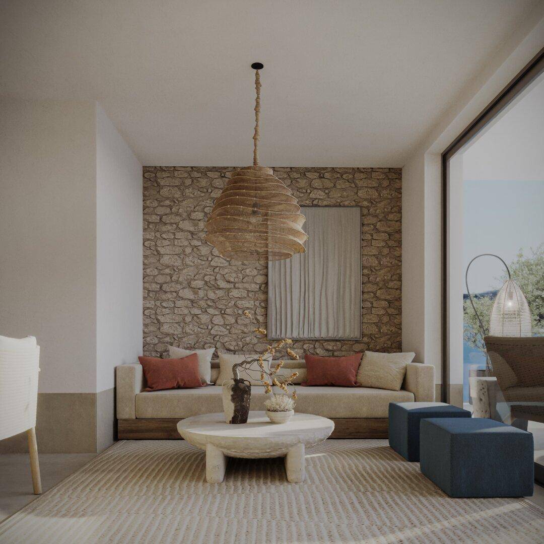 Lichtdurchflutetes Wohnzimmer mit Steinwand, beigem Sofa und modernen Dekorationselementen.