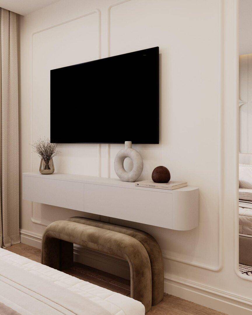 Wandmontierter Fernseher über einer schwebenden Konsole in einem modern eingerichteten Raum.