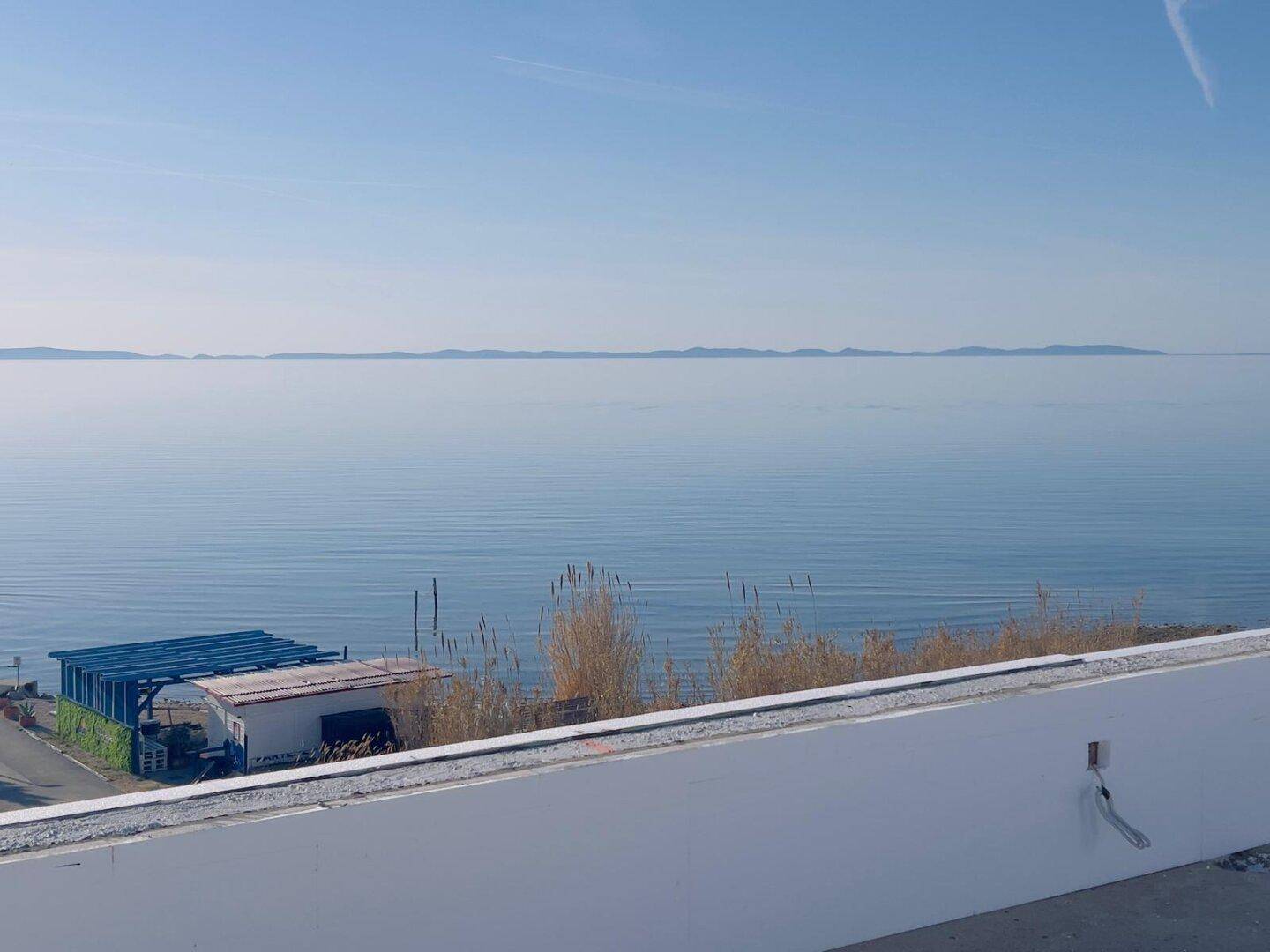 Weitblick über das ruhige Meer unter einem klaren blauen Himmel.