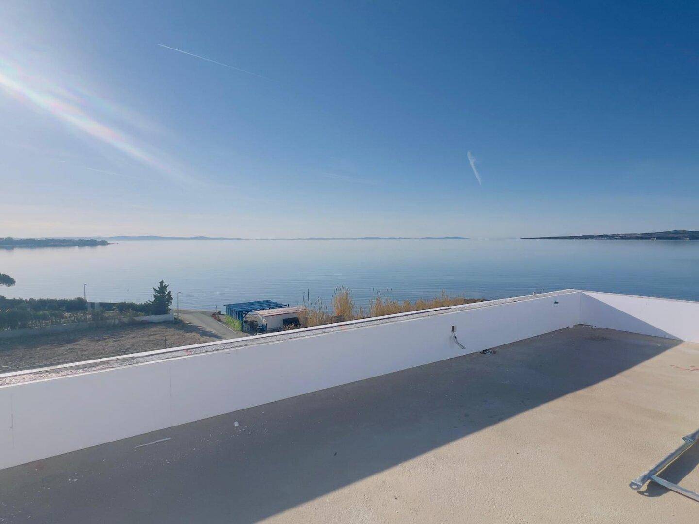 Weitläufiges Flachdach mit Panoramablick auf das ruhige Meer und die Küste.