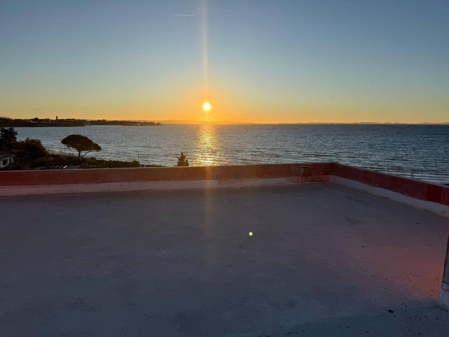 Flachdach mit weitem Meerblick bei Sonnenuntergang, ideal für eine zukünftige Dachterrasse.