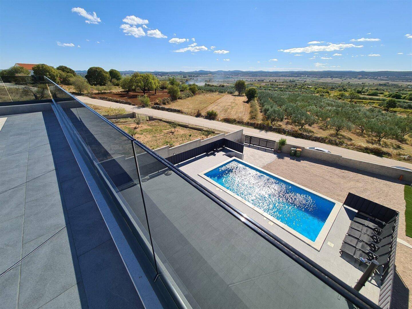 Weitläufige Außenanlage mit Pool und Blick auf die umliegende Natur.