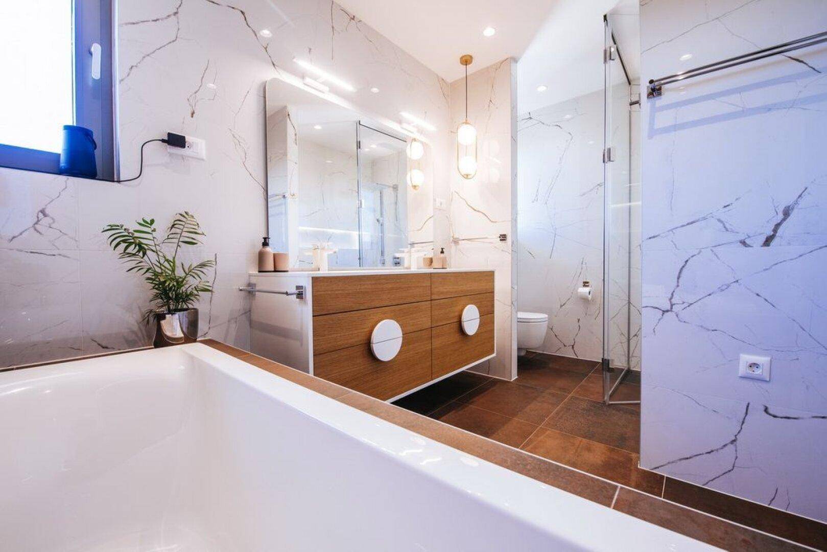 Modernes Badezimmer mit Marmorfliesen, Doppelwaschbecken, Badewanne und begehbarer Dusche.