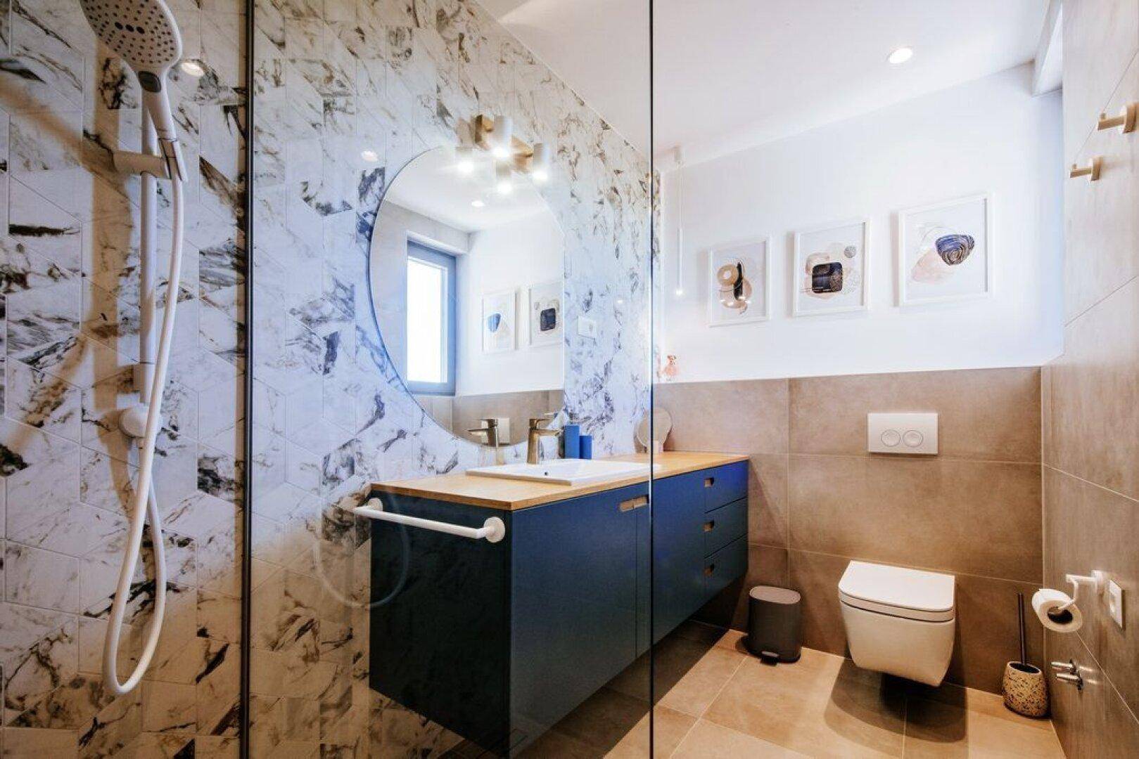 Modernes Badezimmer mit begehbarer Dusche, Einzelwaschbecken und wandhängendem WC.
