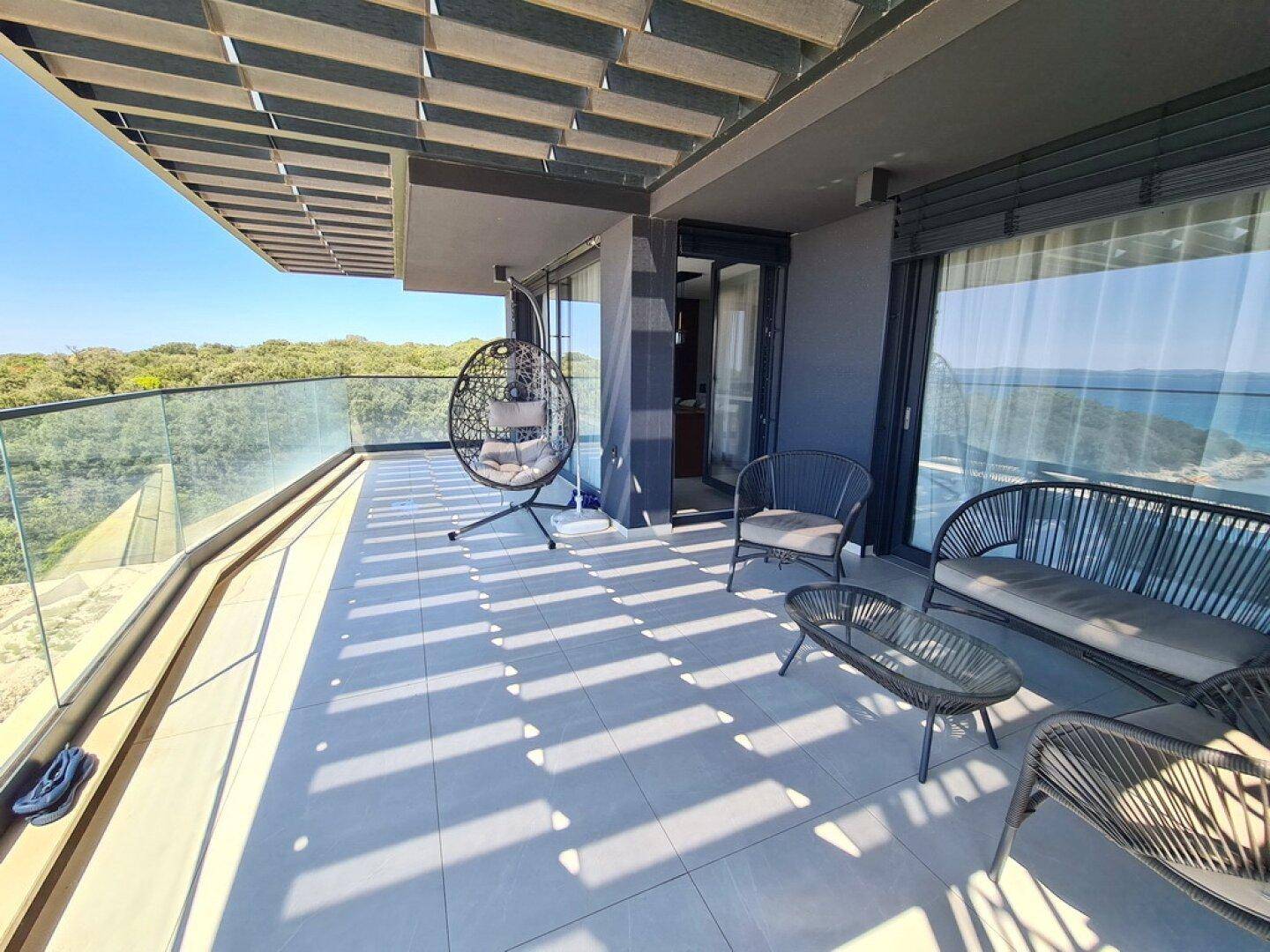 Geräumiger Balkon mit Meerblick, bequemen Sitzgelegenheiten und Sonnenschutz für entspannte Stunden.