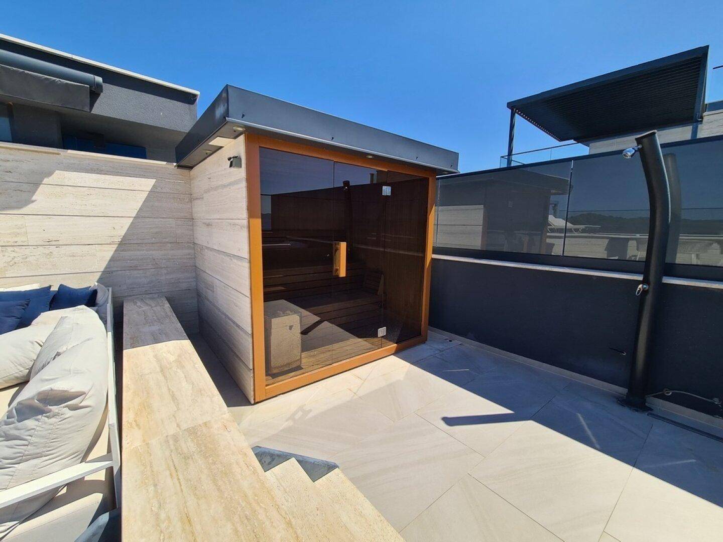 Dachterrasse mit moderner Sauna, Außendusche und luxuriösem Ambiente für Wellness-Momente.