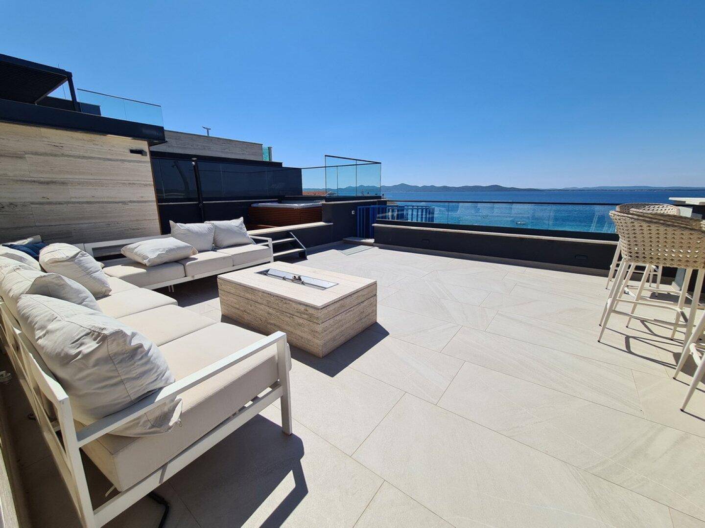 Weitläufige Dachterrasse mit Meerblick, Lounge-Bereich und Whirlpool für ultimative Entspannung.