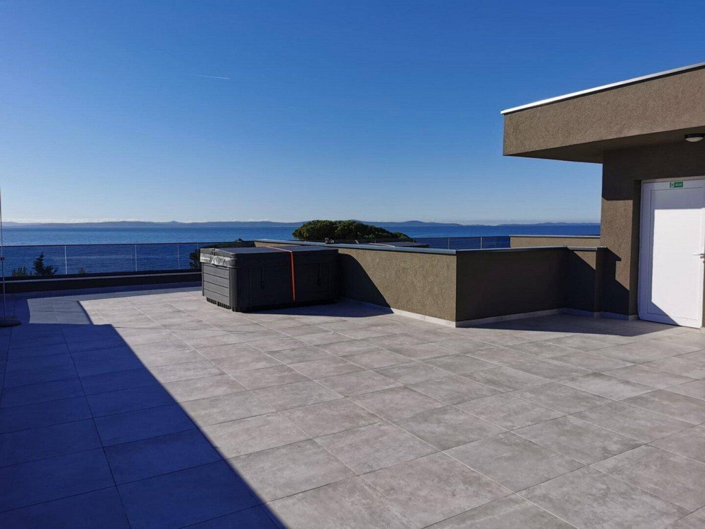 Große Dachterrasse mit Whirlpool und atemberaubendem Meerblick, ideal zum Entspannen und Genießen.