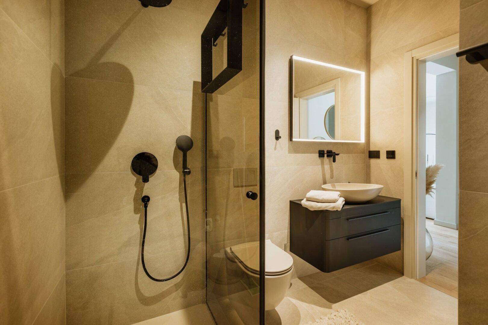 Elegantes Badezimmer mit begehbarer Dusche, Hänge-WC und modernem Waschtisch.