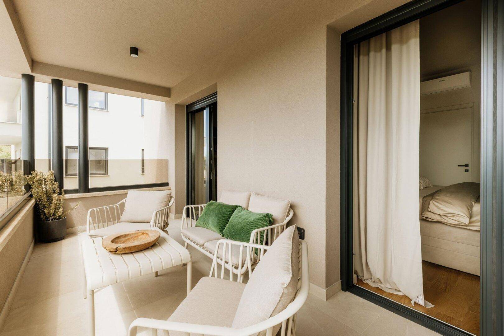Möblierter Balkon mit bequemen Sitzgelegenheiten und Blick auf die Umgebung.